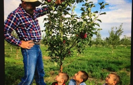 Orchardist with young pickers