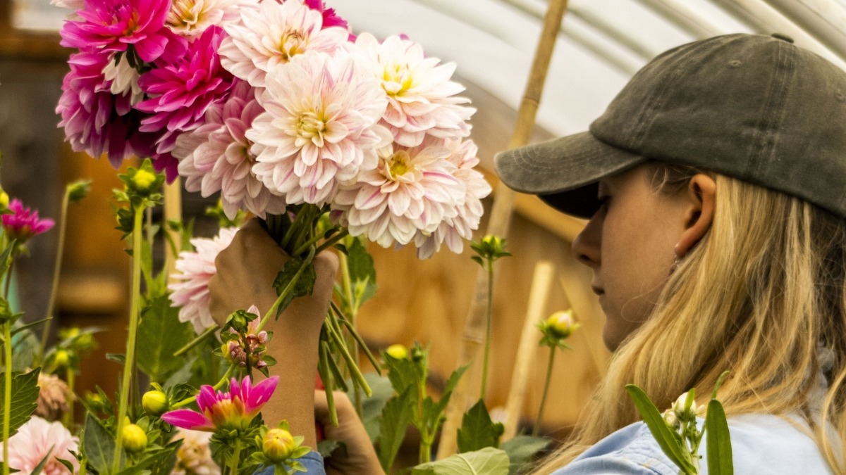 a person holding flowers in a hoophouse