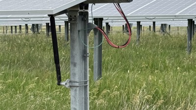 Snapshot of corner of solar panel at 100 degree angle. Showcasing lush vegetation and good wire management