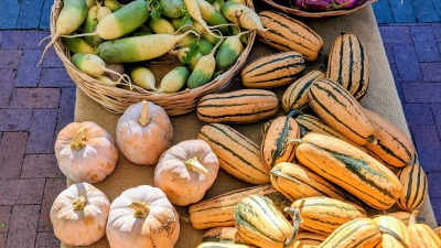 Fall market table with winter squash, roots and fruits.