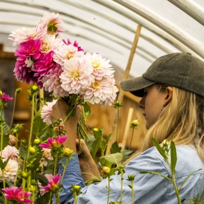 a person holding flowers in a hoophouse